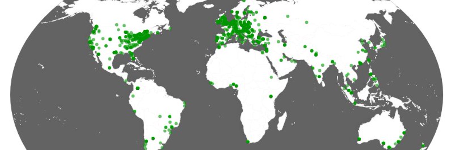 A flattened globe with grey seas and white land masses. Green dots represent the locations of members, The are all over the world, but concetrated in North America and Europe.